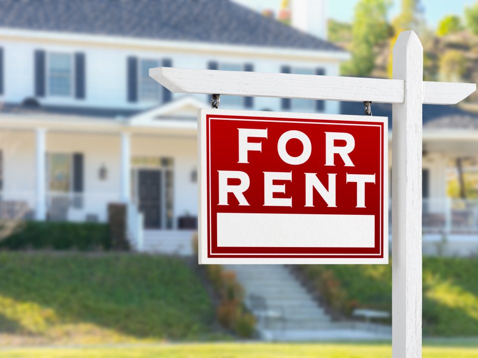 Left Facing For Rent Real Estate Sign In Front of House.